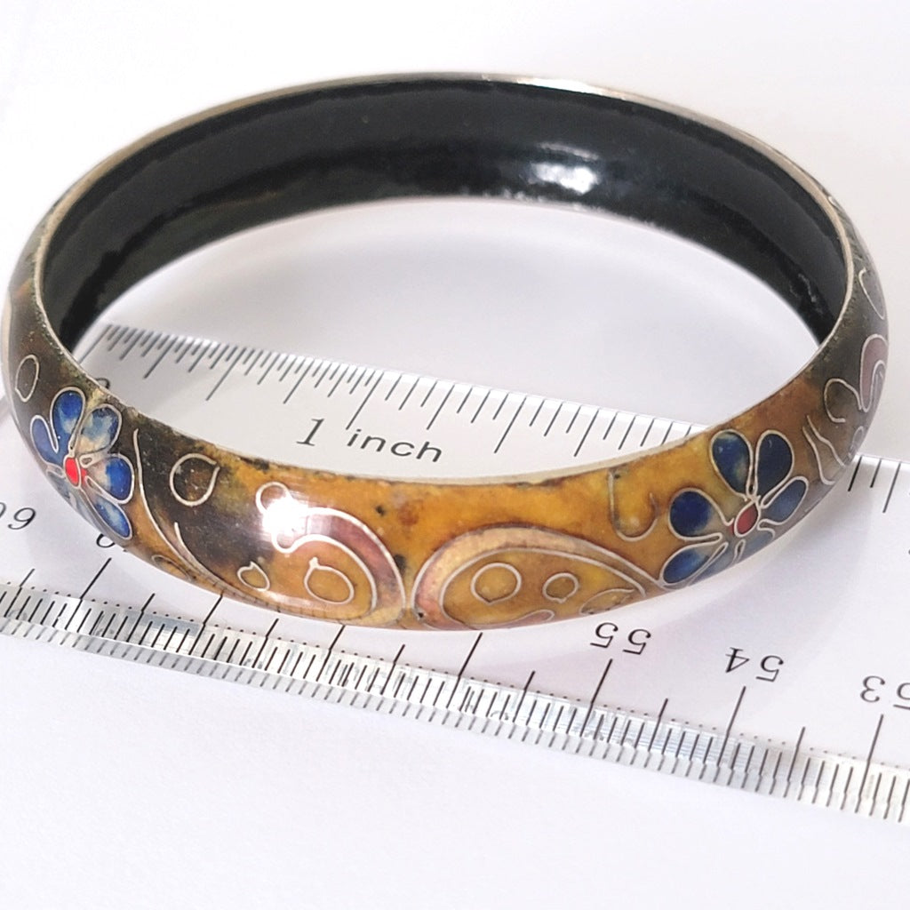 Blue floral cloisonne bracelet, next to a ruler.