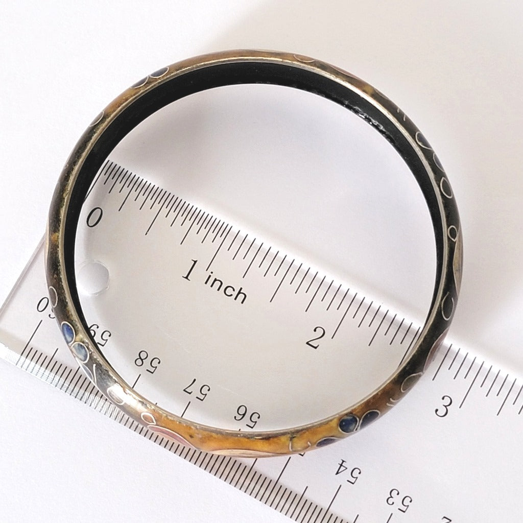 Cloisonne bracelet next to a ruler.