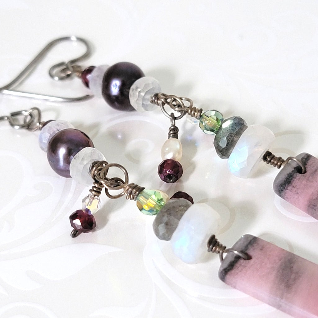 Close-up view of gemstone and crystal dangling earrings.