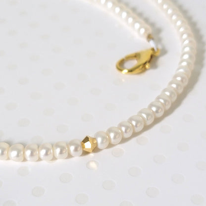 Close-up view of small pearls and gold crystal beads.