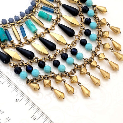 Close-up view of gold metal and faux turquoise beads on a Stella and Dot necklace.