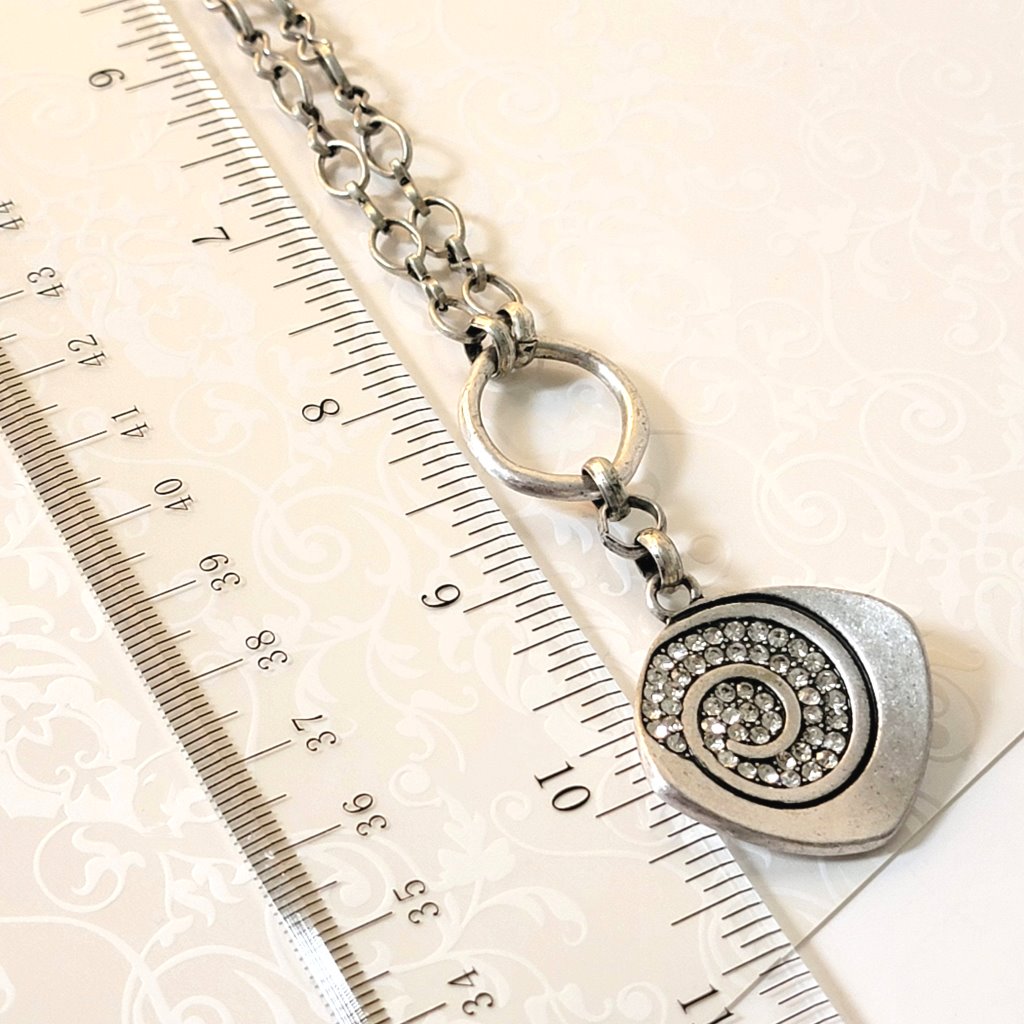Closeup view of a Premier Designs rhinestone pendant, next to a ruler.