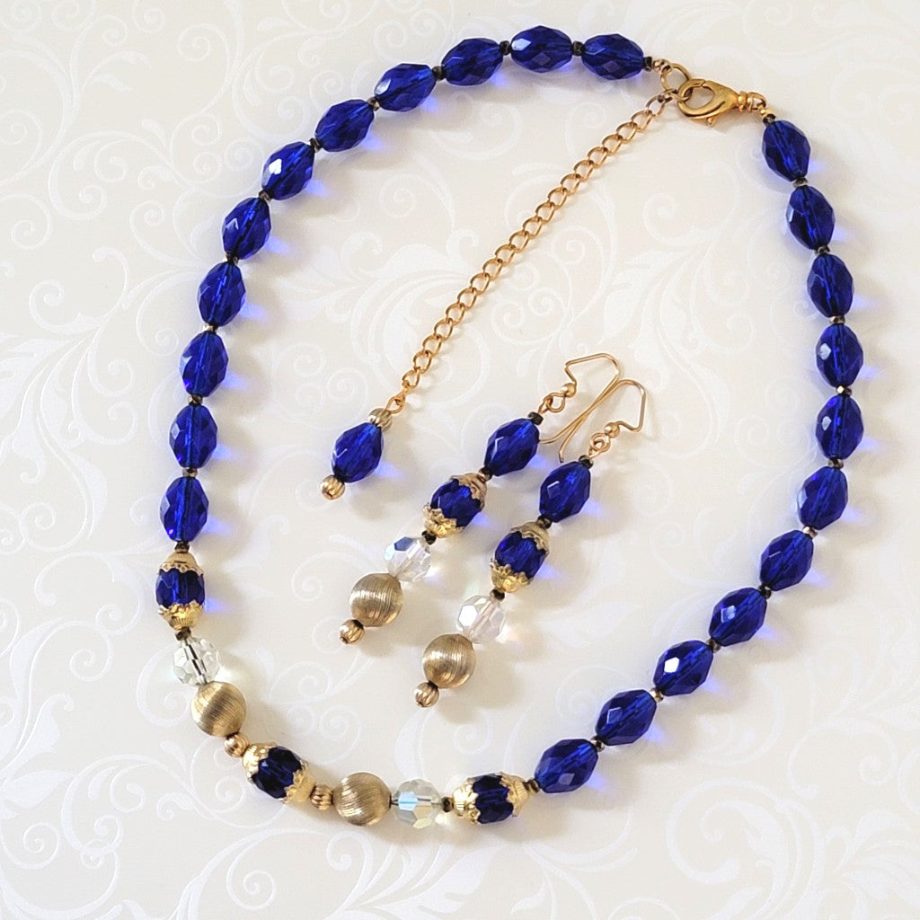 Bright blue glass beaded necklace and earrings set, with gold tone accents. Showing long extender chain.