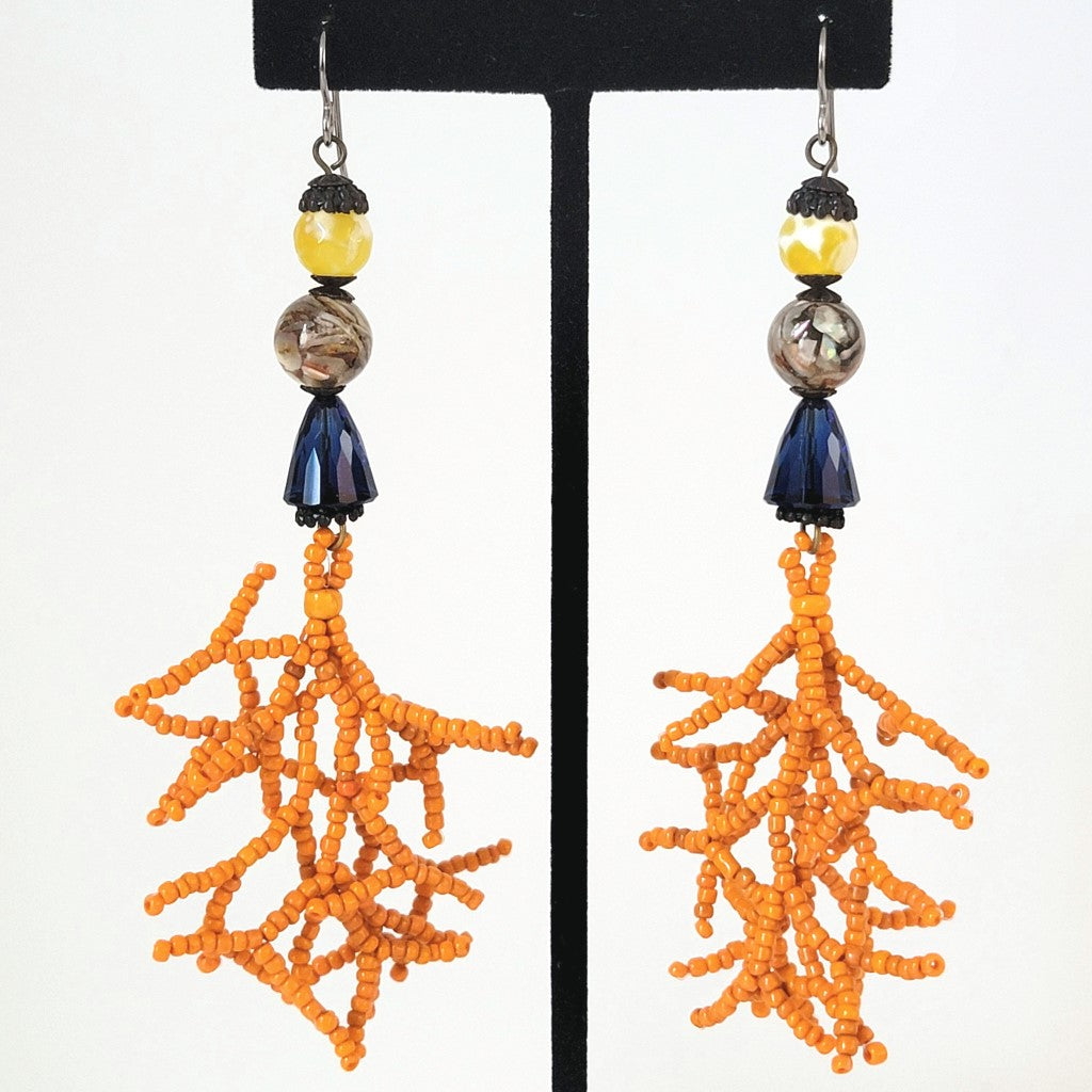 Long dangle earrings with yellow stones, blue crystals and coral seed bead branches.