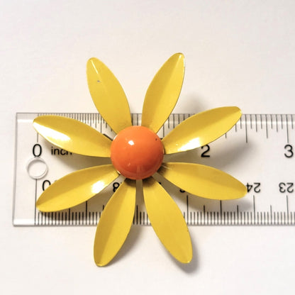 Yellow flower brooch with ruler.