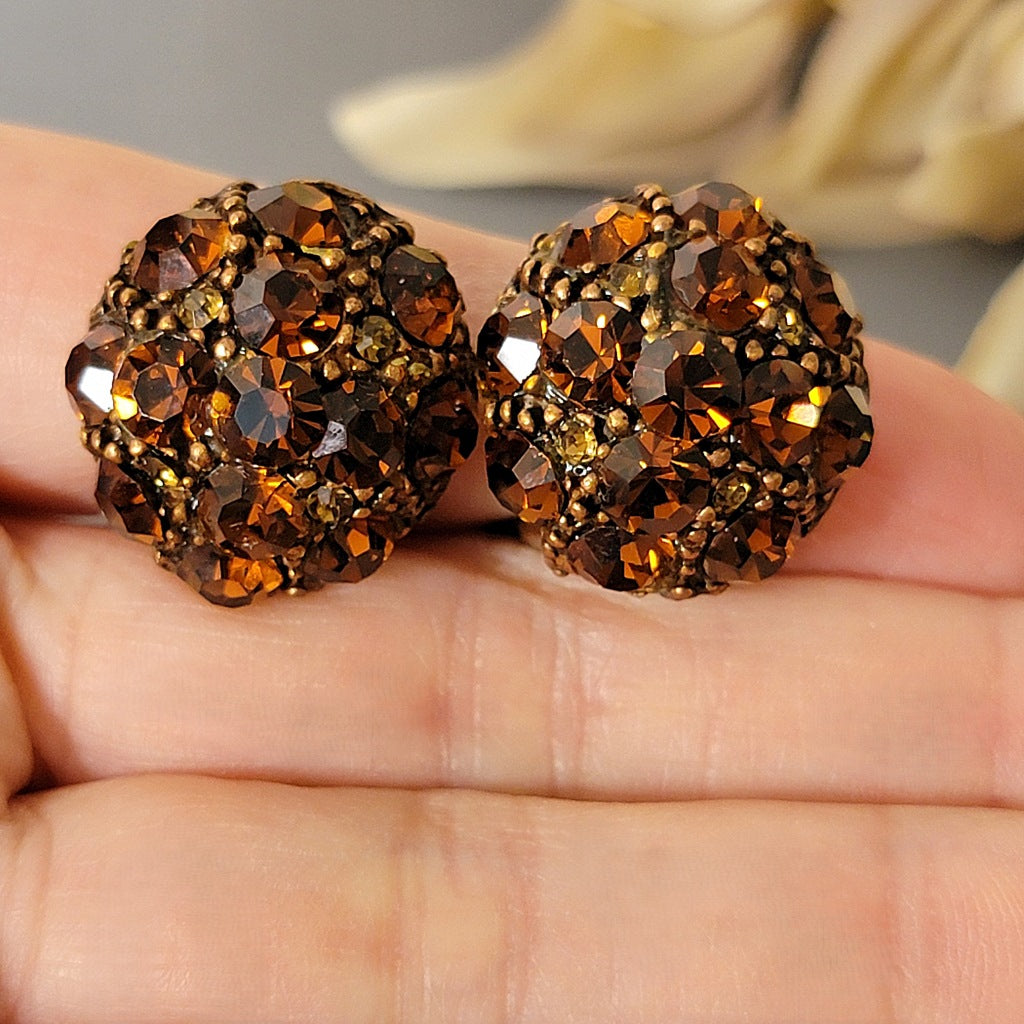 Rhinestone button style earrings in hand.