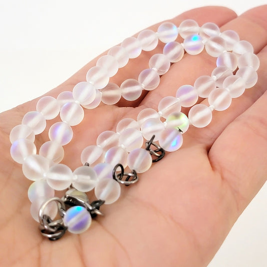 Iridescent glass beaded necklace in hand.