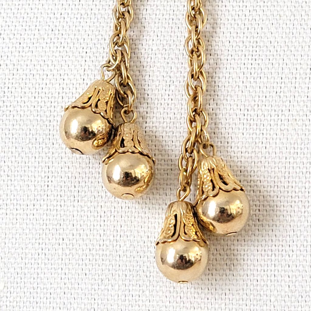 Gold tone beads on necklace.