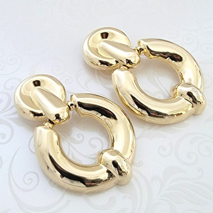 Large gold tone door knocker style clip-on earrings.