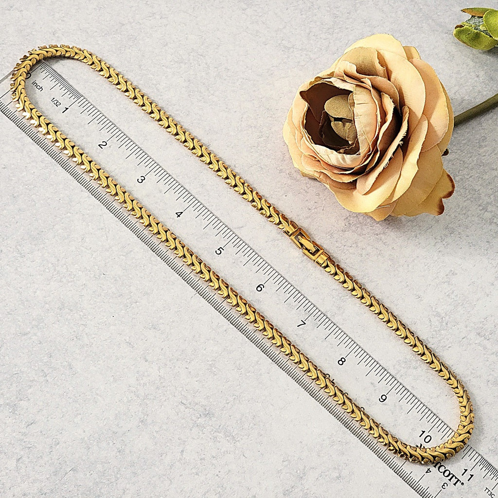 Vintage gold chain necklace next to a ruler.