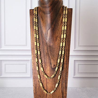 Long gold chain on a jewelry display stand.
