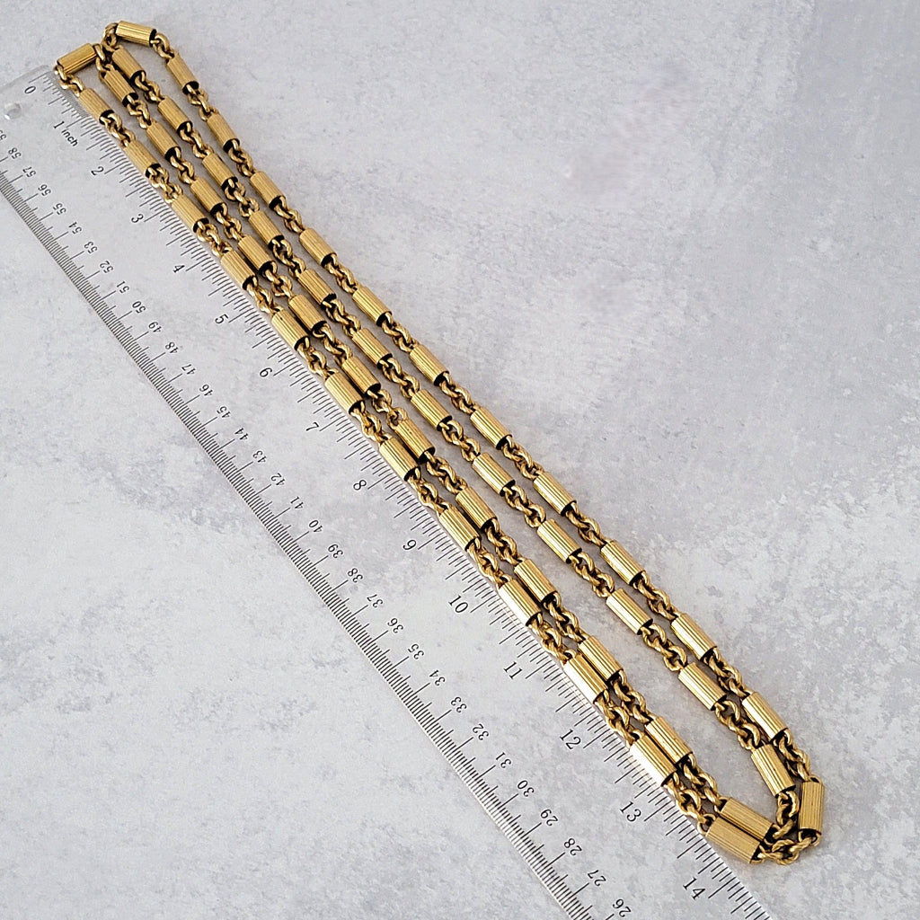 Vintage gold tone chain next to a ruler.