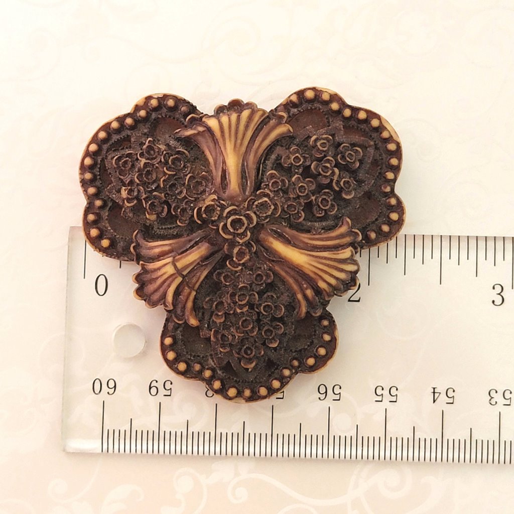 Vintage goth flower brooch, shown next to a ruler.