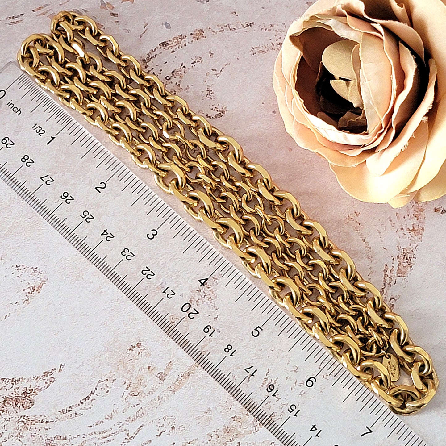 Gold chain necklace next to a ruler.