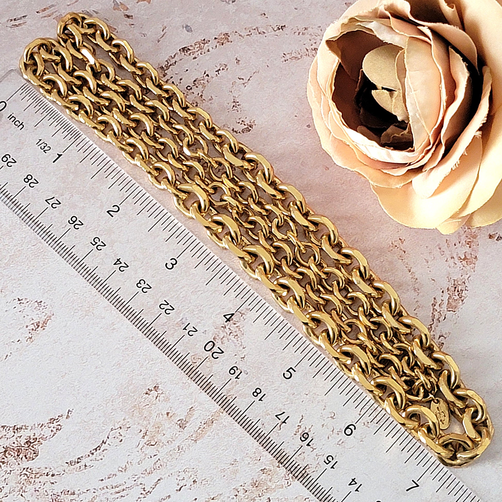 Gold chain necklace next to a ruler.