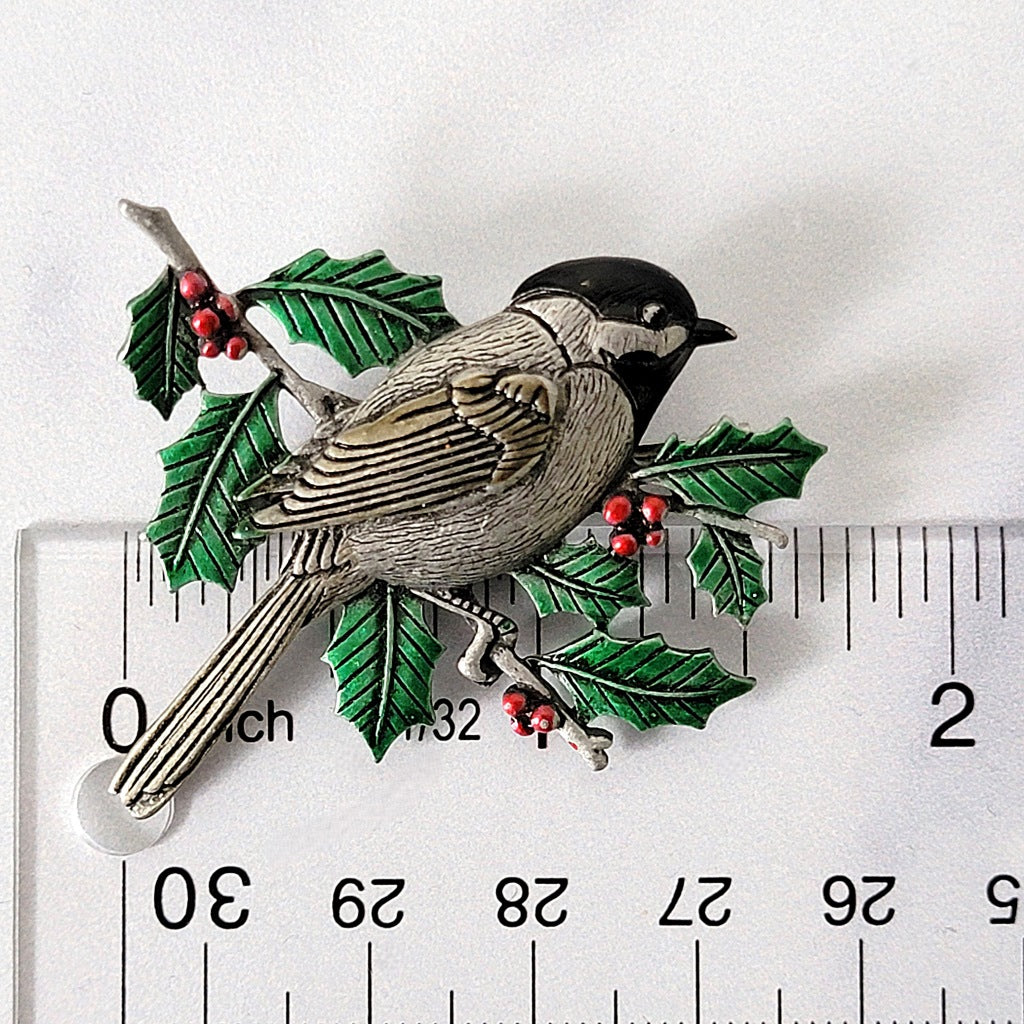 Chickadee bird pin next to a ruler.