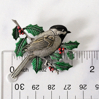 Chickadee bird pin next to a ruler.