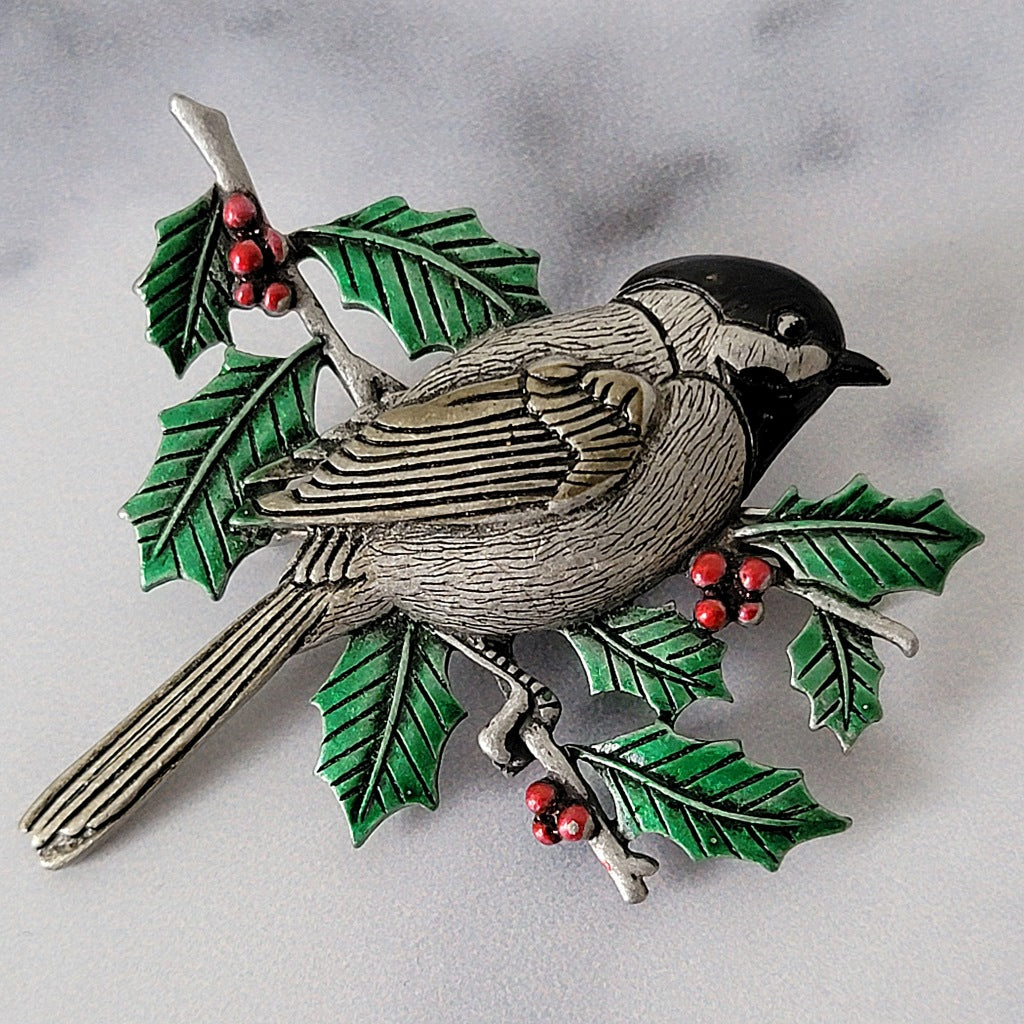 Chickadee brooch with holly leaves.
