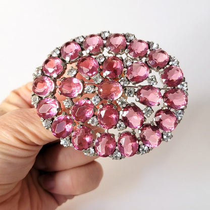 Pink rhinestone brooch in hand.