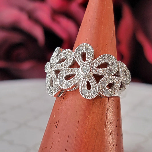 Silver tone floral rhinestone ring.