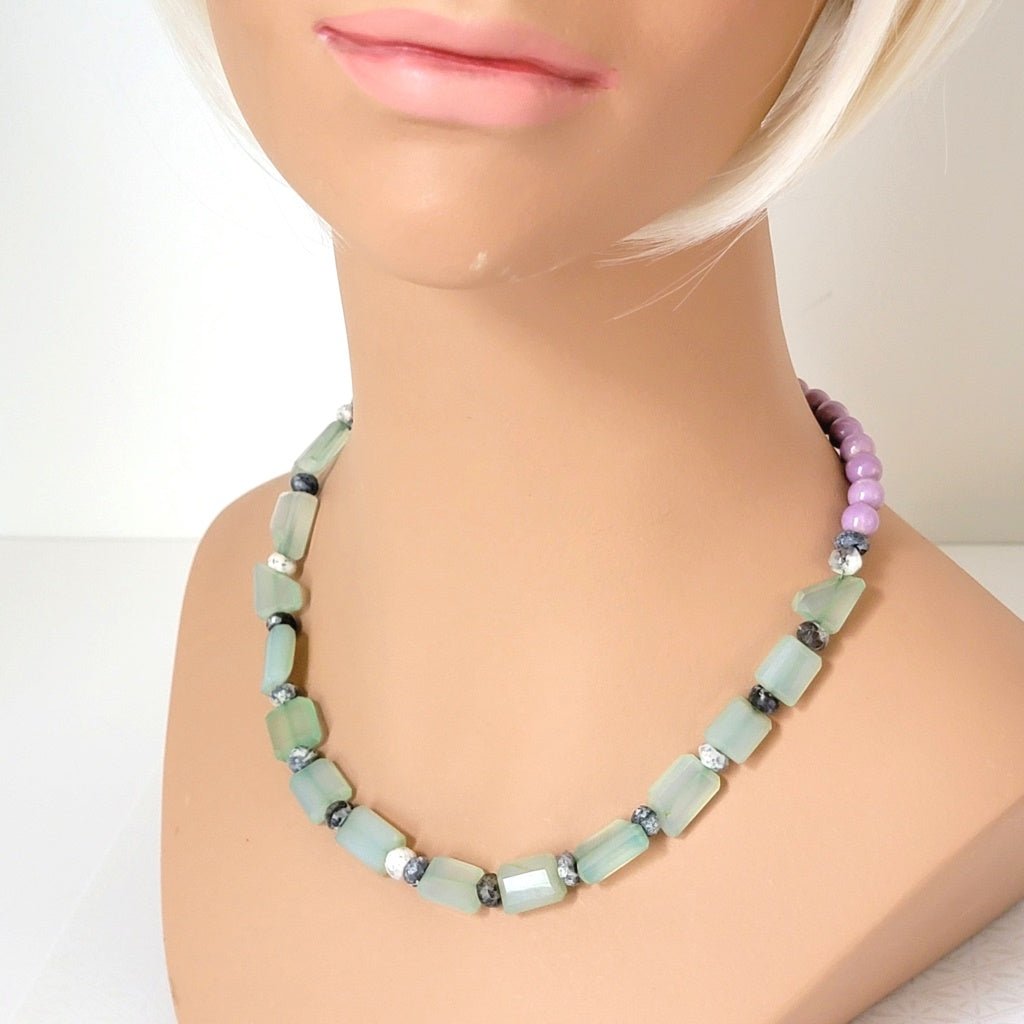 Pastel green and purple stone necklace, shown on a mannequin.