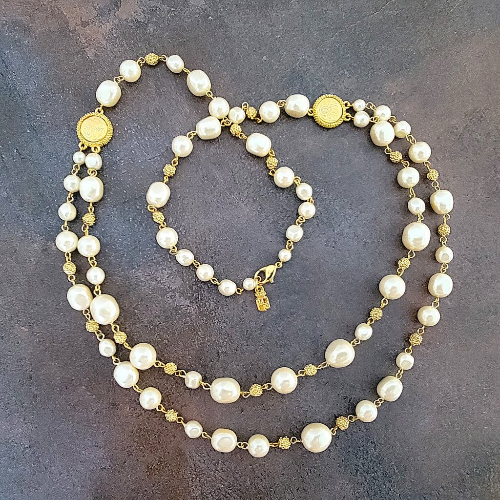 Long faux pearl necklace, double strand, with gold tone accents.