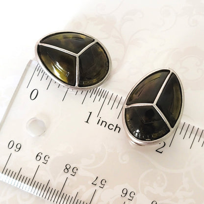 Claiborne scarab earrings, shown next to a ruler.