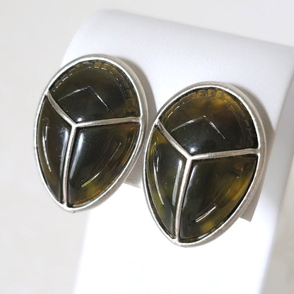Liz Claiborne scarab beetle clip on earrings, shown on a display stand.