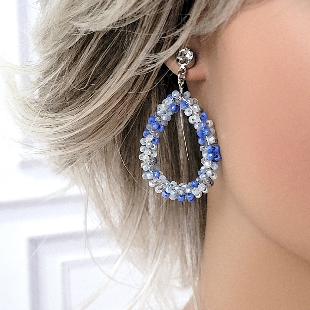 Blue beaded teardrop earring on mannequin.