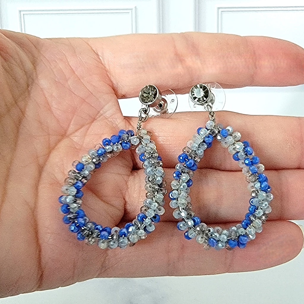 Blue beaded dangle earrings in hand.