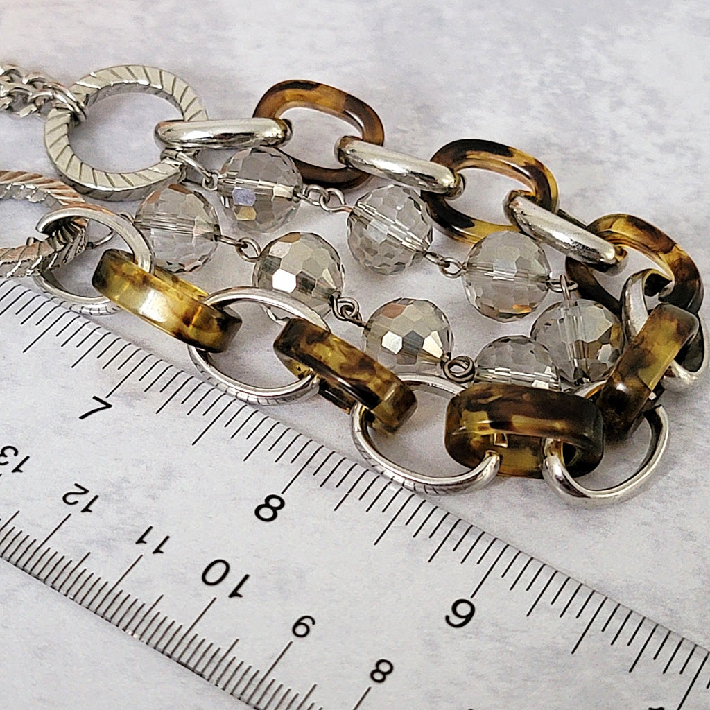 Acrylic links and glass beads next to a ruler.