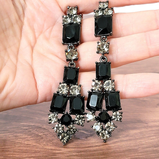 Big black rhinestone dangle earrings in hand.