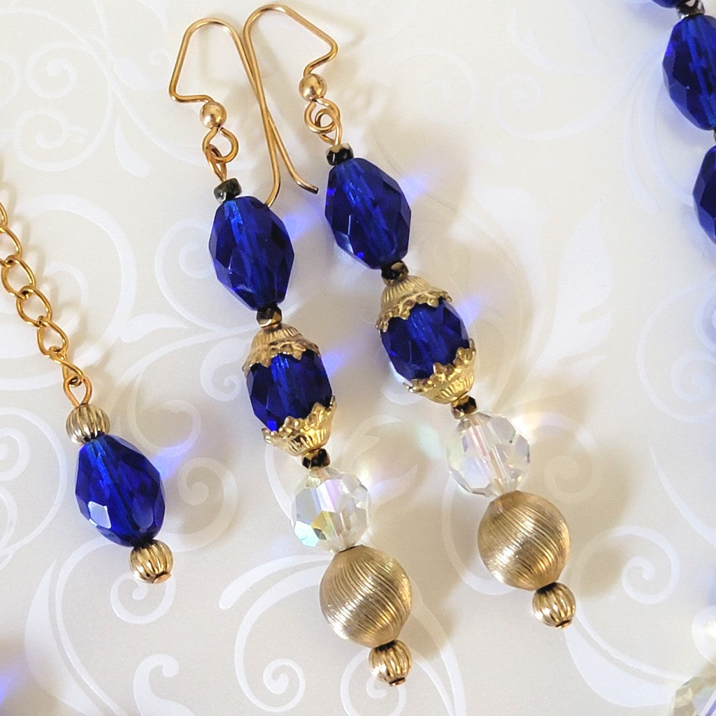 Long dangling blue glass earrings, with gold tone accents.
