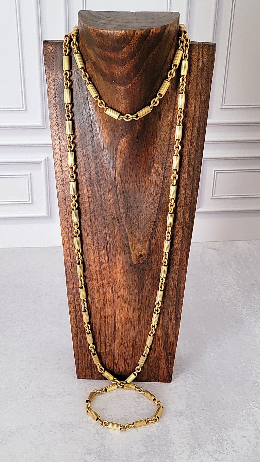 Long vintage gold chain on a display stand.