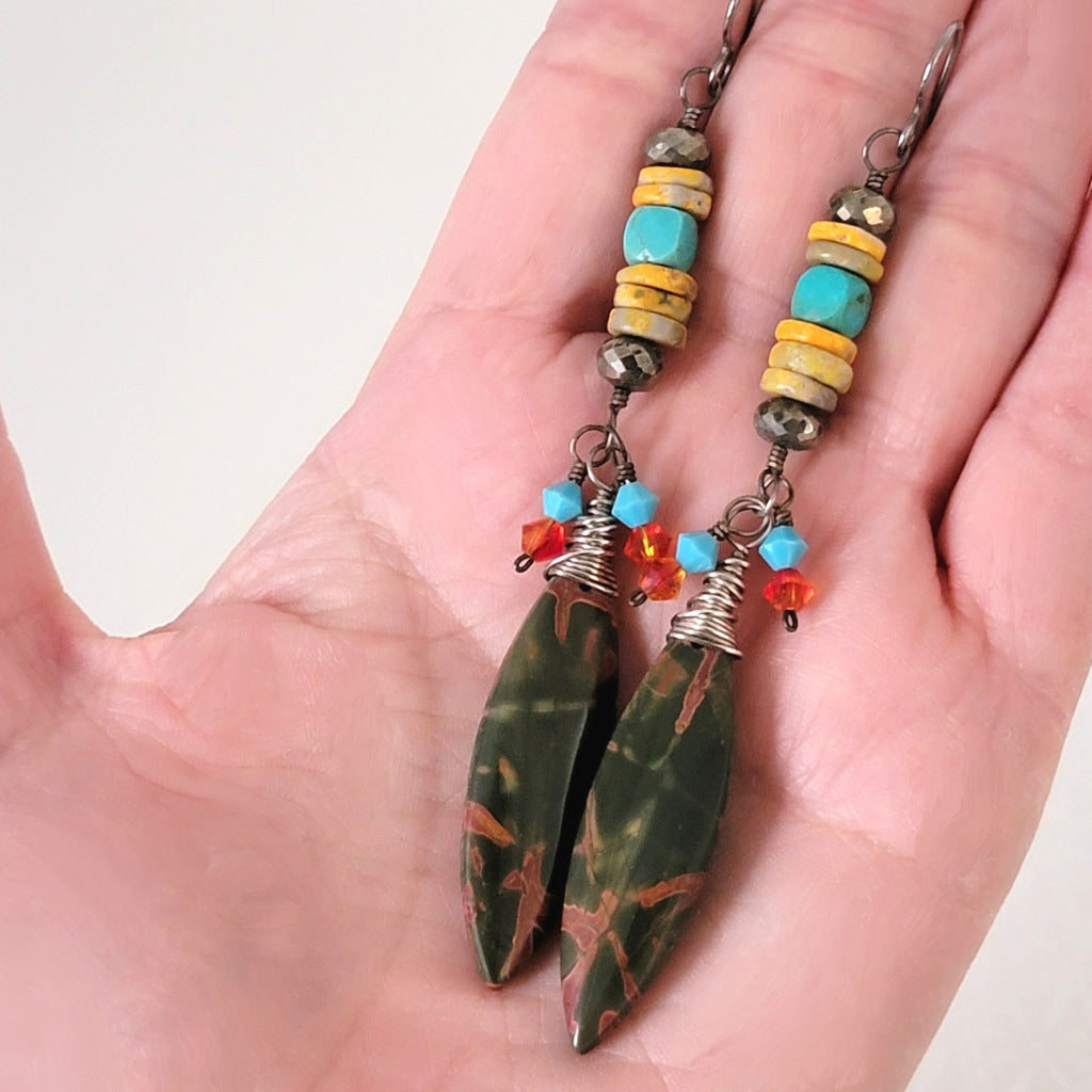 Long red creek jasper earrings, shown in hand, for size comparison.