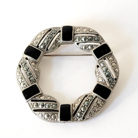 Silver tone brooch with black enamel and marcasite rhinestones.