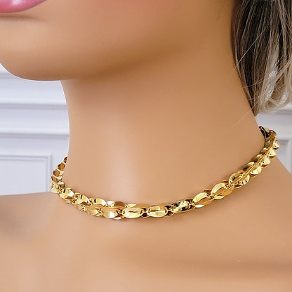 Gold tone link choker necklace on a mannequin.