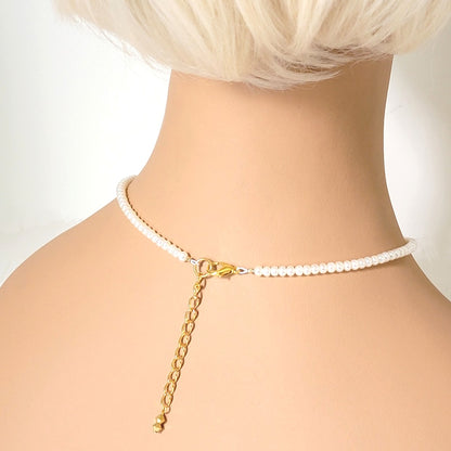 Back view of minimalist pearl choker, shown on a mannequin.
