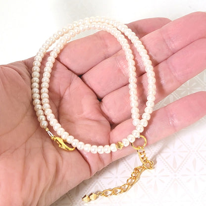 Minimalist pearl choker, with gold plated clasp and chain. Shown in hand, for size comparison.