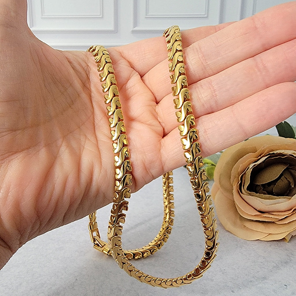 Vintage Monet gold necklace in hand.