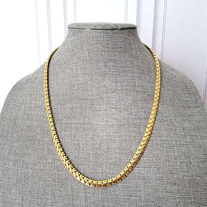 Wide gold tone chain on display stand.