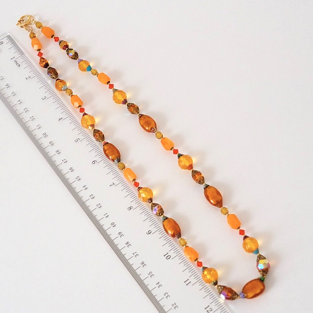 Orange bead necklace with ruler.