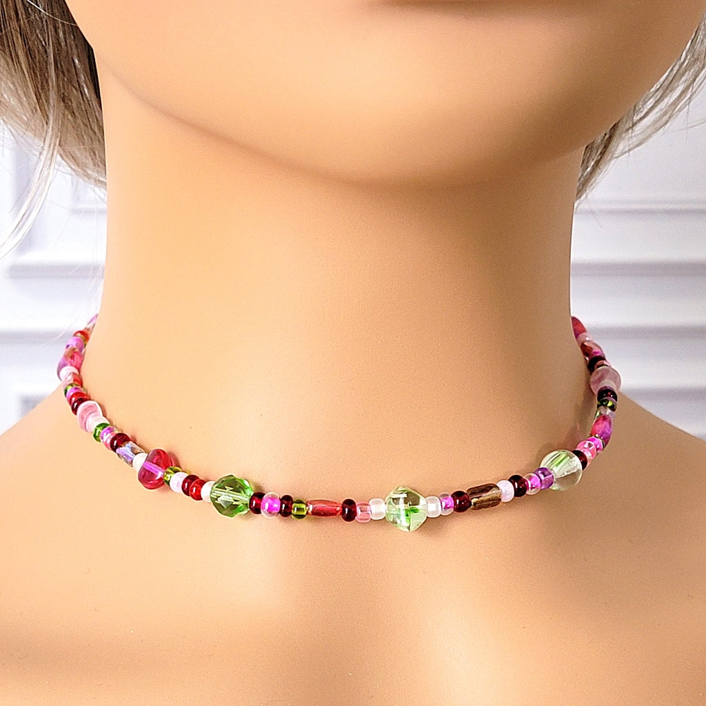 Pink and green beaded choker on a mannequin.