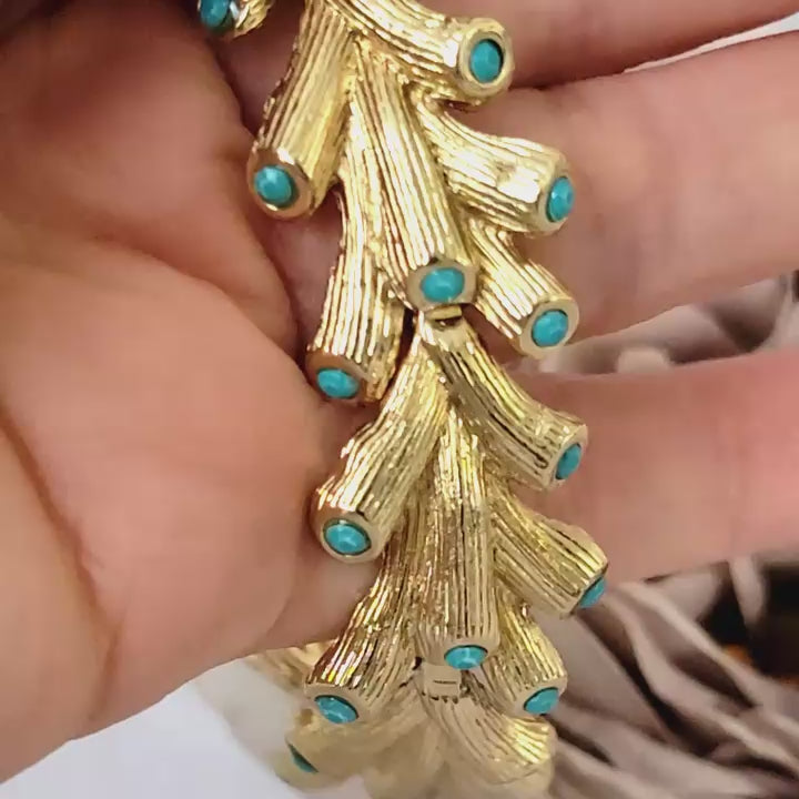 Gold tone link bracelet with small turquoise acrylic rhinestones.