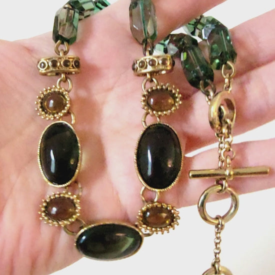 Monet green necklace in hand.