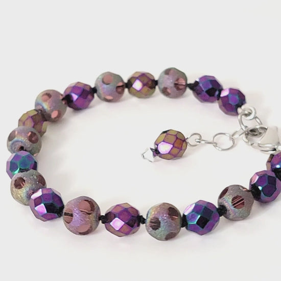 Purple beaded bracelet displayed on a turntable.