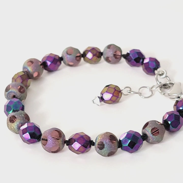 Purple beaded bracelet displayed on a turntable.