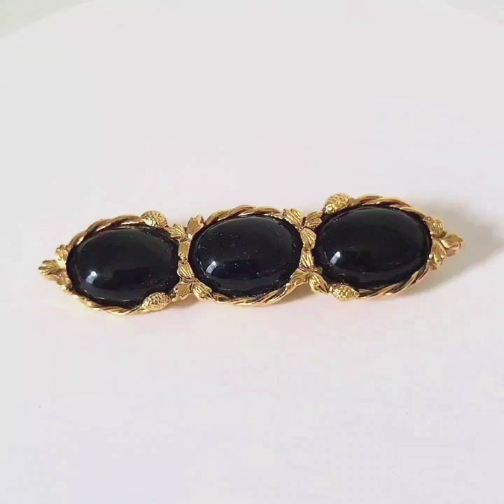 Video of a vintage 1928 black and gold brooch.