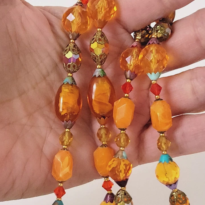 Orange beaded necklace in hand.