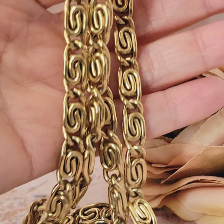 Vintage thick gold tone chain necklace in hand.